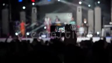 手拿唱片摄像机智能手机现场音乐会表演拍照音乐乐队剪影跳舞的人